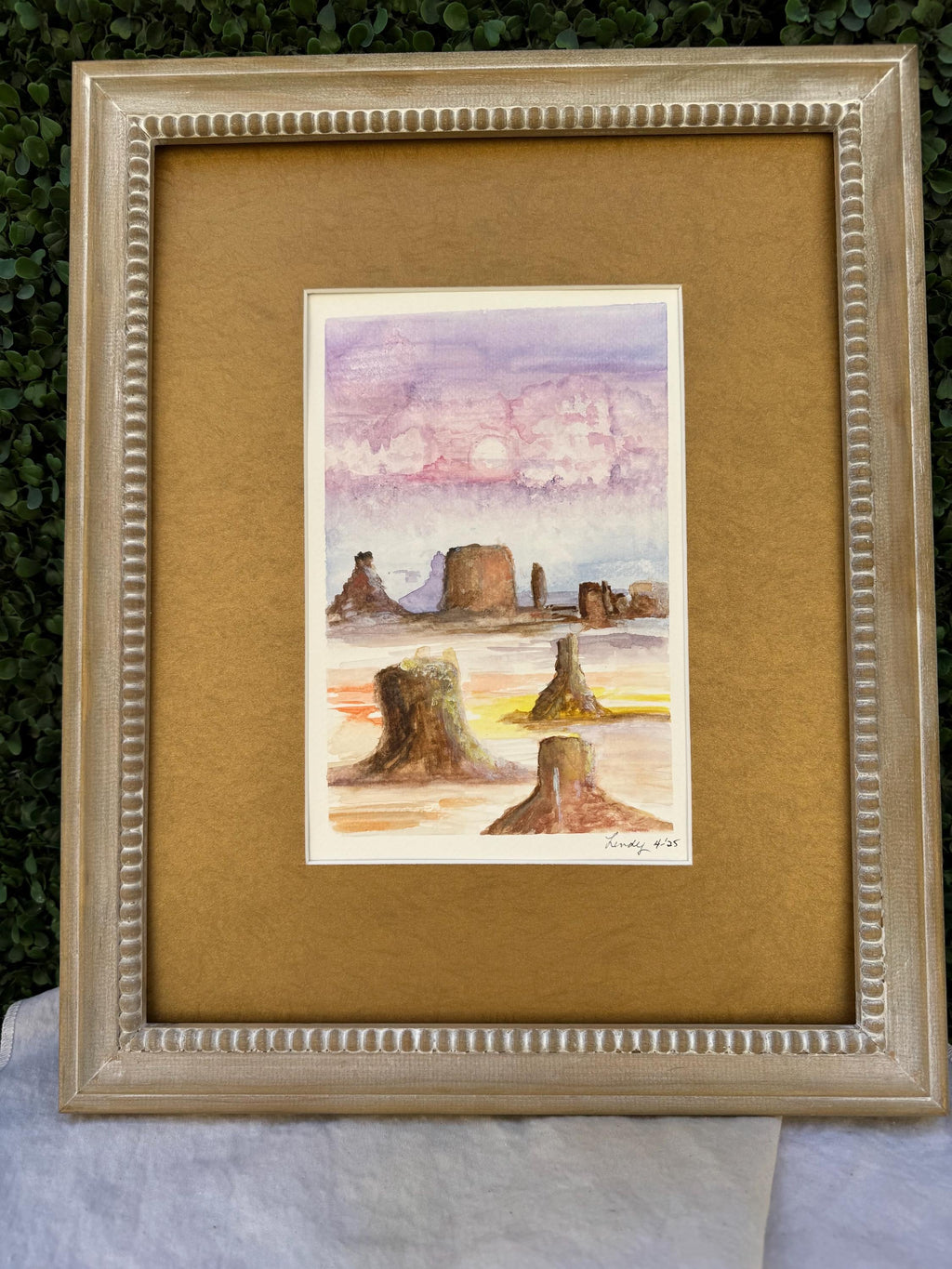 Watercolor painting depicting colorful Monument Valley in pastel light.