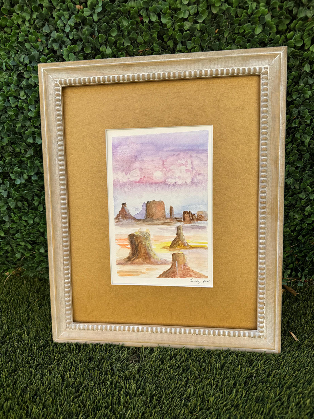 Watercolor painting depicting colorful Monument Valley in pastel light.