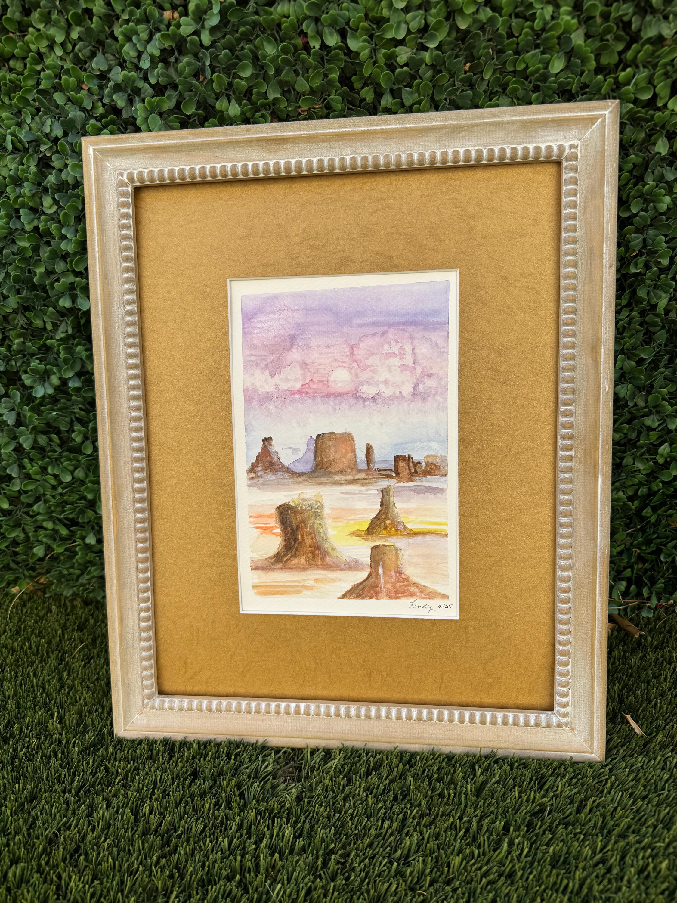 Watercolor painting depicting colorful Monument Valley in pastel light.